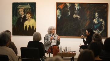 Event in gallery with two women speaking 